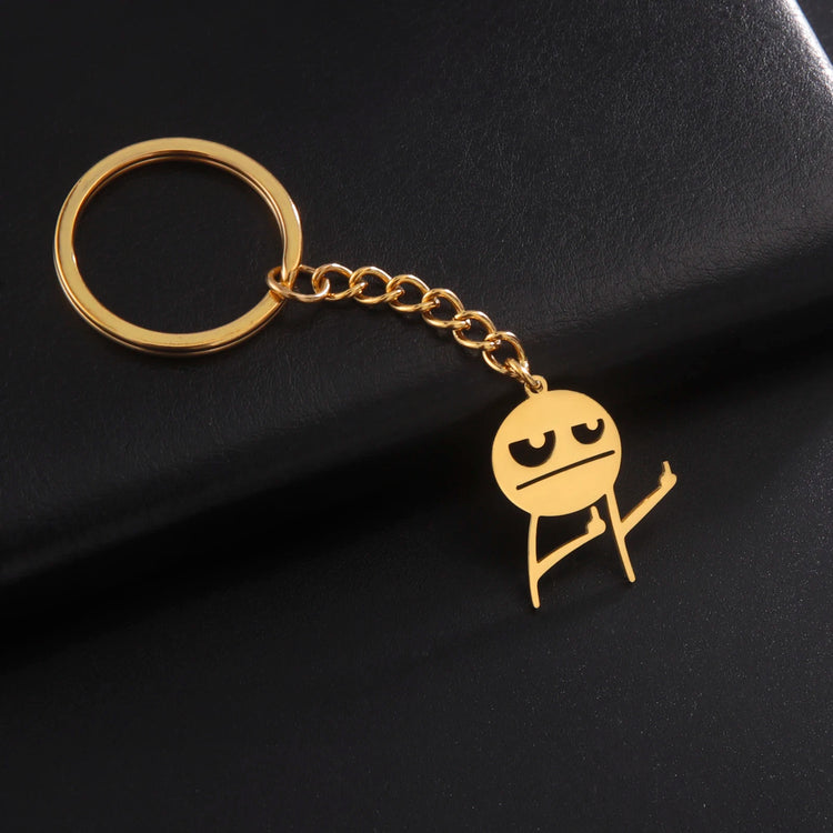 Gold Keychain holding up 2 middles fingers on a black background resting on a leather plate
