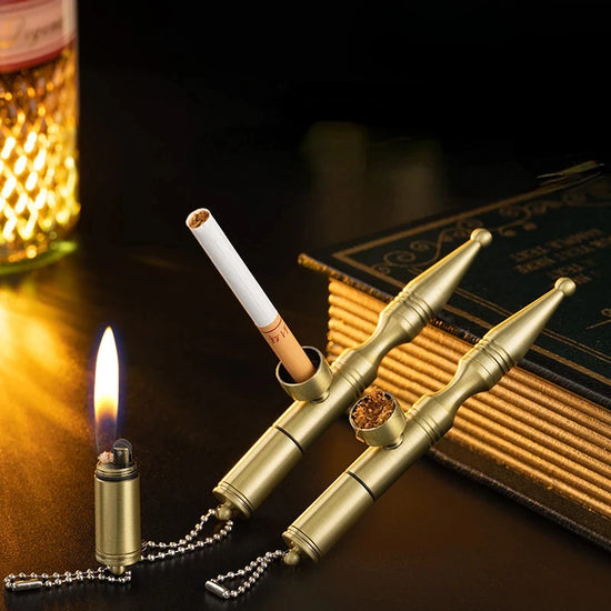 Gold 2 in 1 smoking pipe and lighter set on a dark surface with a lit candle and book in the background.